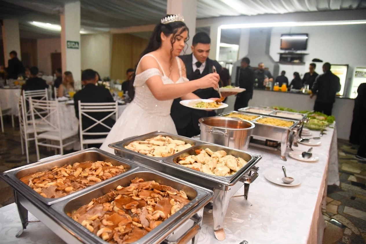 Noivos se servindo no buffet completo do Espaço Lia Coelho