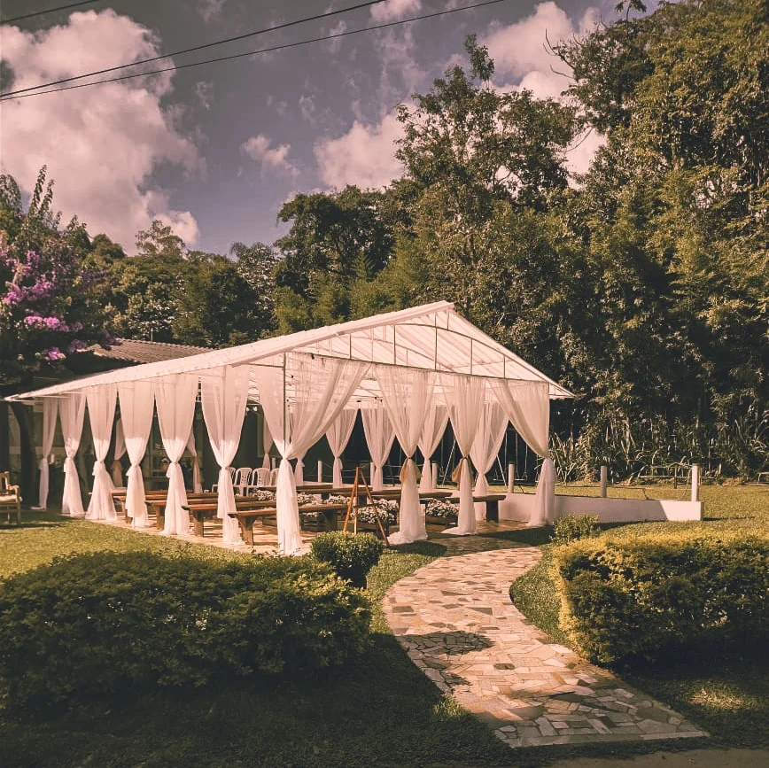 Vista externa da chácara Lia Coelho, com estrutura coberta e jardim
